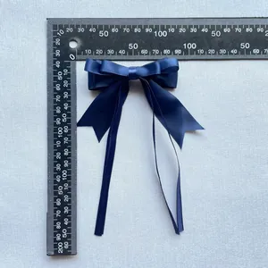 Mesure détaillée d'un nœud en satin bleu marine avec de longs rubans suspendus