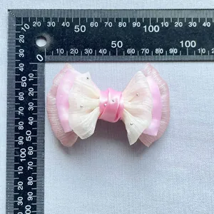 Fiocco in nastro rosa con perle d'argento da 85 mm di larghezza su superficie grigia