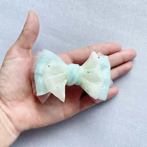 Dettaglio di fiocco in tulle multistrato rosa e blu con piccoli strass argentati