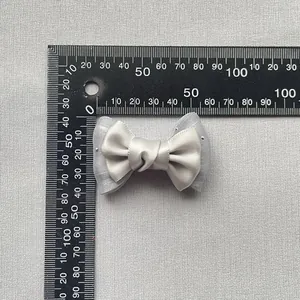 Detailed view of a 6cm double-layer grey satin and mesh bow with delicate beads