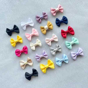 Macro detail of assorted colorful 3cm satin ribbon bows for DIY craft and garment decor
