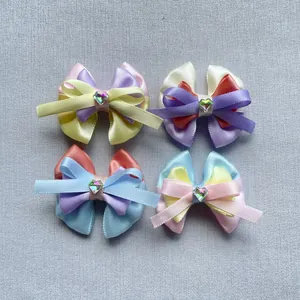 Détail de quatre nœuds en satin multicouches avec gemmes en cœur pour cheveux et poupées