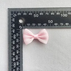 Lazo de malla rosa con purpurina, de 40 mm de largo, medido sobre una regla negra
