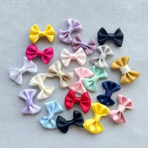 Flat lay of colorful 3cm handmade satin ribbon bows for DIY hair accessories and crafts