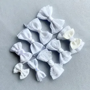 Detail van diverse witte kant en satijn DIY strikken met parels voor haar en tas decoratie