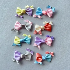 Flachbild von bunten Satin-Schleifen-Accessoires mit Strasssteinen in Pastellkombinationen