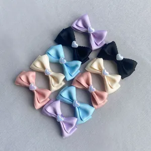 Dettaglio di fiocchi fatti a mano colorati con perle a forma di cuore iridescenti