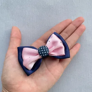 Détail d'un nœud en satin double épaisseur rose et bleu marine avec strass brillants