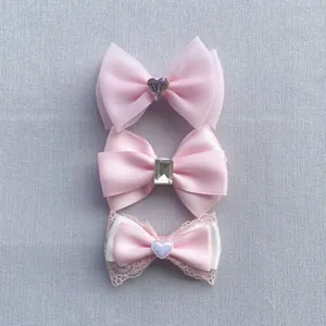Three assorted pink DIY bow hair clips featuring lace ribbons, organza and heart rhinestones