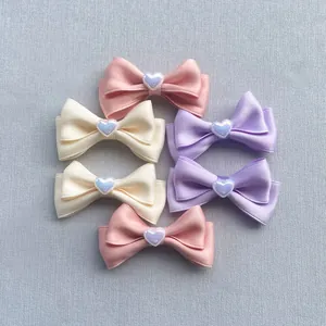 Dettaglio di fiocchi in raso fatti a mano con perle a forma di cuore in set da 6