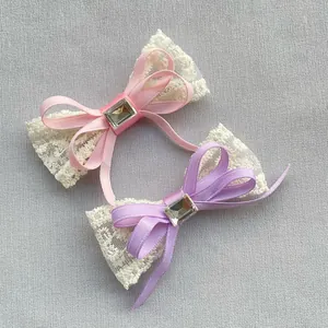 Dettaglio di fiocchi in pizzo fatti a mano rosa e viola con nastri e strass quadrati