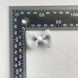 Detalle de lazo gris 40x25mm con pequeños brillantes para accesorios de pelo DIY