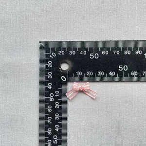 Close-up of 15mm pink polka dot mini ribbon bow for DIY doll clothes and crafts