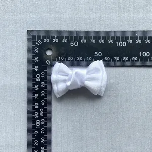 Detailweergave van een witte satijnen DIY-strik met een breedte van 4 cm op de liniaal