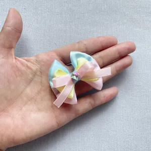 Détail d'un nœud en satin tricolore de 4 cm avec un strass brillant au centre
