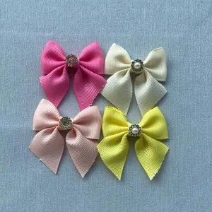 Detailed view of grosgrain ribbon bows with rhinestone and pearl flower centers