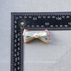 Vista detallada de un lazo de triple capa de 5cm con perla para decorar frascos de perfume