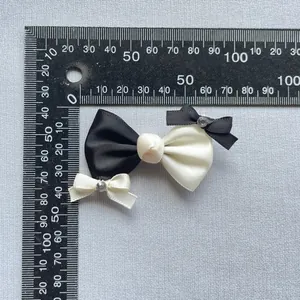 Detailansicht einer 70mm handgefertigten schwarz-weißen Schleife mit Diamanten und Lineal