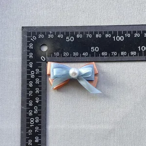 Detalle de lazo de satén artesanal de 40mm con perla para frascos de perfume DIY