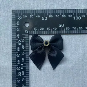 Black grosgrain ribbon bow with blue gemstone and rhinestones, measuring 5.5cm x 6cm