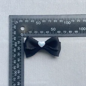 Dettaglio fiocco di raso nero 40mm con perla a cuore bianca e scala graduata