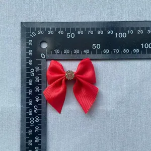 Red grosgrain ribbon bow with pink rhinestone center for hair accessories and crafts