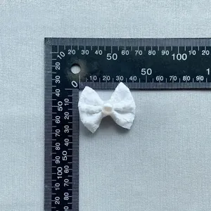Detail van de witte kanten DIY strik met parel, ongeveer 45mm bij 35mm groot