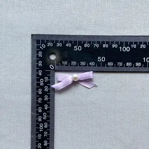 Macro detail of a 30mm light purple satin bow with pearl for cake topper and crafts