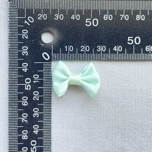Close-up measurement of a 3cm mint green satin ribbon bow for DIY accessories