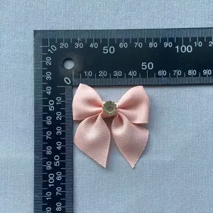 Detail of pink grosgrain ribbon bow with a crystal rhinestone center measuring 50mm