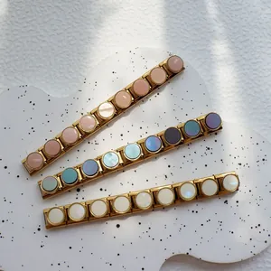 Dettaglio macro di tre bracciali componibili italiani dorati con inserti colorati DIY