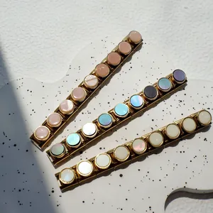 Dettaglio dei bracciali Italian Charm dorati con inserti circolari colorati in conchiglia