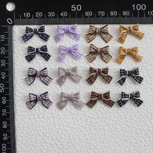 Detalle de mini lazos de cuadros en varios colores con regla mostrando tamaño de 30mm