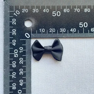Close-up of a 3cm black satin bow accessory showing fine fabric texture and measurements