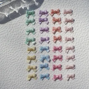 Macro view of assorted 1cm satin ribbon bows in pastel colors for DIY craft and doll decor