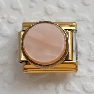 Dettaglio charm modulare italiano dorato con inserto in resina rosa perlata