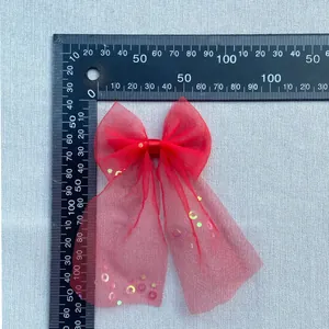Size detail of red mesh bow with sequins measuring 160mm in length and 85mm in width