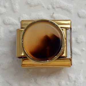 Vista macro di una maglia per bracciale italiano dorato con pietra in resina ambra marrone