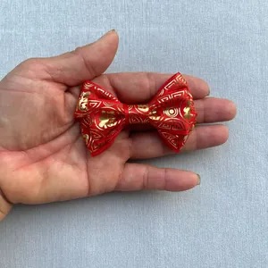 Close-up of handmade red satin bow accessory with golden Fu character pattern