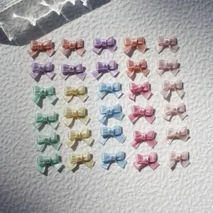 Detailed view of colorful 1cm mini satin ribbon bows for DIY doll clothes and crafts