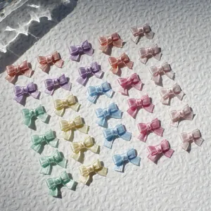 Macro detail of multi-colored 1cm mini satin ribbon bows for DIY doll clothes and crafts