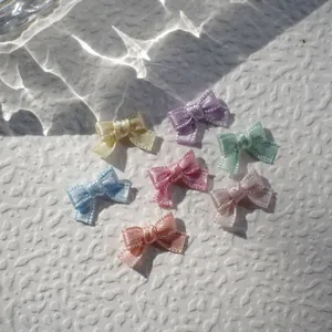 Detailed view of colorful 1cm mini satin ribbon bows for DIY doll clothes and crafts