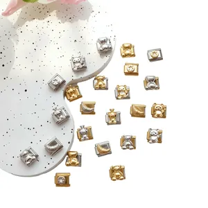 Macro detail of Italian charm links with teddy bear and croissant motifs in gold and silver