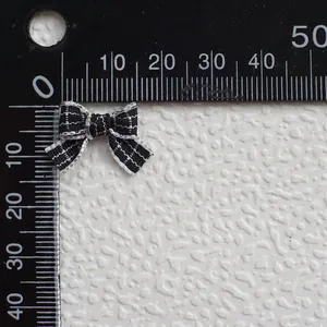Primer plano de lazo de tela a cuadros blanco y negro de 25 mm con regla graduada