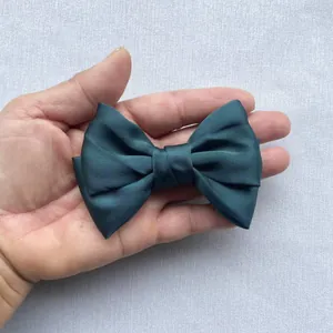 Macro shot of dark green satin double layer bow with glossy finish for hair accessories