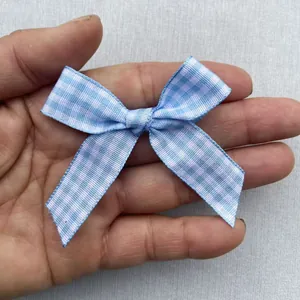 Detail shot of a small blue and white plaid ribbon bow for DIY clothing and hair accessories