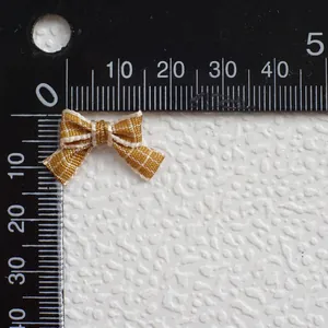 Vista macro de mini lazo de cuadros amarillos de 25mm para ropa de muñecas DIY