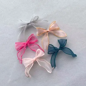 Détail de nœuds en ruban organza translucide pour la création d'accessoires de coiffure