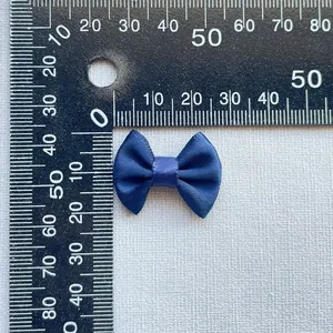 Macro detail of navy blue satin ribbon bow with measurement scale for size reference