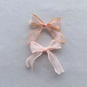Détail de nœuds élégants en mousseline rose avec bord doré pour accessoires cheveux DIY
